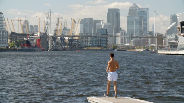 Eine-sehr-jungen-Mann-mit-nacktem-Oberkörper-aber-passen-Docklands-von-London,-England.