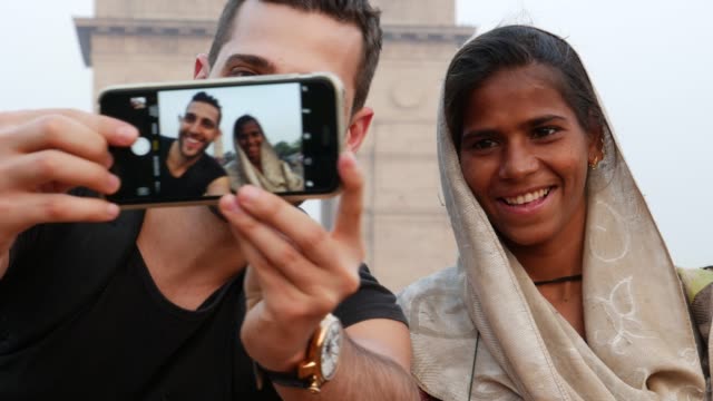 Turista-tomando-una-selfie-con-una-mujer-en-la-puerta-de-la-India,-Nueva-Delhi