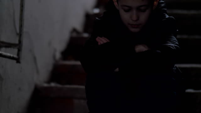 boy-sits-alone-in-an-old-ramshackle-demolition-house,-regrets-the-incident,-cold-weather