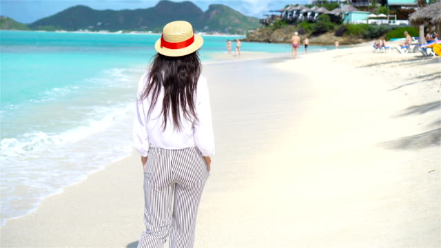 Junge-schöne-Frau-am-tropischen-Strand.-Glückliches-Mädchen-Hintergrund-der-blaue-Himmel-und-türkisfarbenes-Wasser-im-Meer-auf-Karibik-Insel
