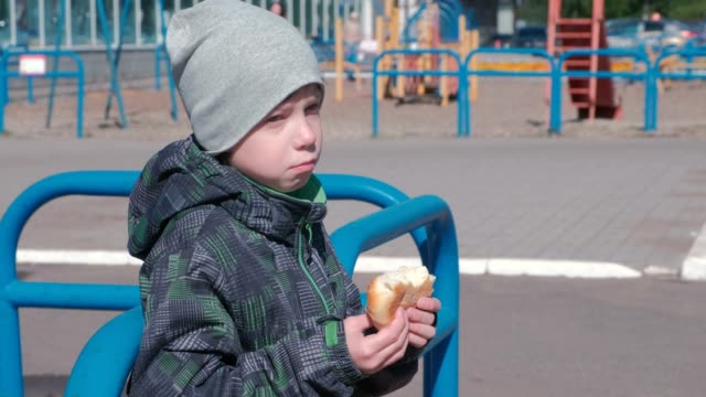 Boy-eating-a-bun-on-the-Playground.