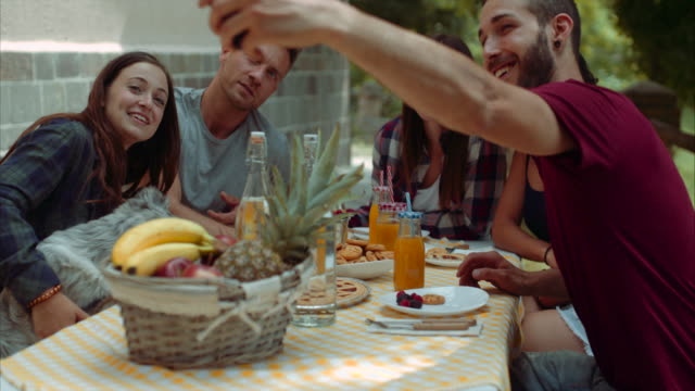 group-of-friends-doing-breakfast-outdoors-in-a-traditional-countryside.-shot-in-slow-motion