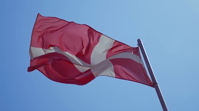 Dänemark-Fähnchen-im-Wind-mit-blauem-Himmel