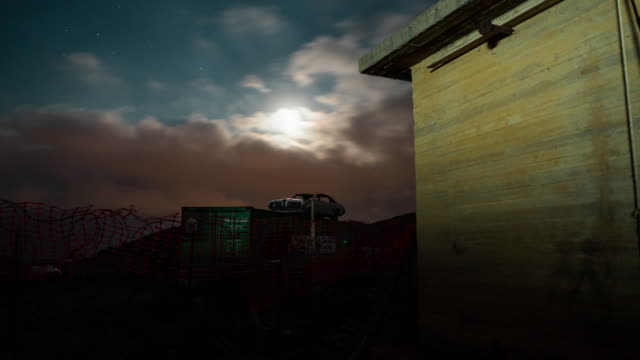Zeitraffer-von-Auto-auf-Container-mit-dramatischen-Mond-und-Wolken-in-der-Nacht