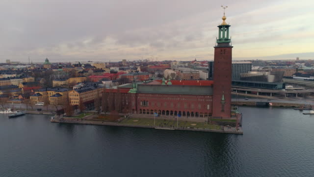 Stockholm-City-Hall-aerial-view.-Drone-shot-flying-around-Stockholm-Town-Hall,-famous-landmark-in-the-Capital-of-Sweden.-Nobel-Prize-building,-cityscape-in-the-background
