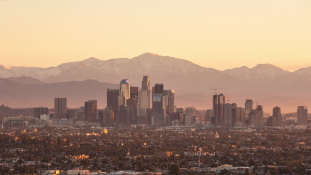 Die-Innenstadt-von-Los-Angeles-mit-Snowy-Mountains-bei-Sonnenaufgang-Timelapse