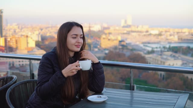 Dame-Kaffeetrinken-auf-der-Terrasse-mit-Blick-in-barcelona