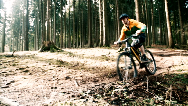Man-on-mountain-bike-rides-on-track-in-forest