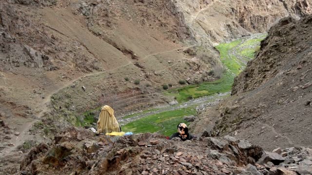 Dos-mujeres-en-vestido-tradicional-de-Marruecos-en-vestidos-de-sentado-en-un-borde-del-acantilado