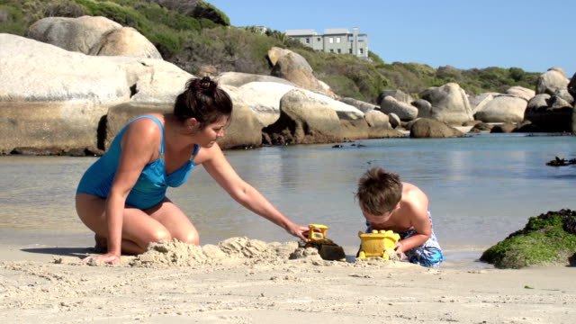 Mutter-und-Kind-spielen-mit-Spielzeug-am-Strand,-Cape-Town
