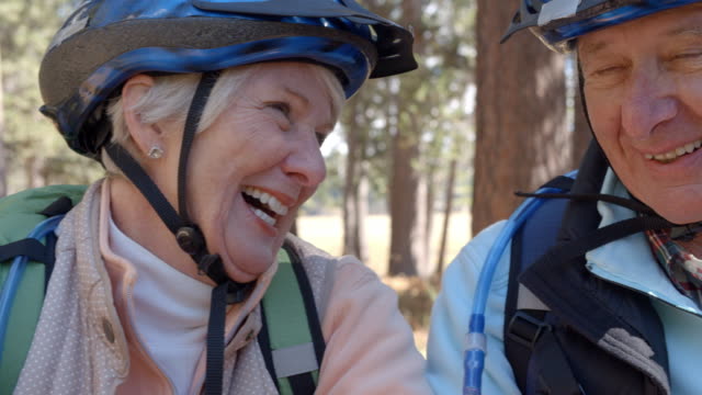 Close-up-shot-of-senior-couple-on-bikes-in-a-forest