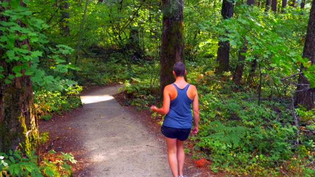 Optimistic-Cancer-Survivor-Woman,-Walking-Down-Forest-Gravel-Path