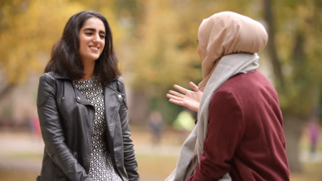 Encuentro-de-dos-mujeres-musulmanas-británicas-en-parque-urbano