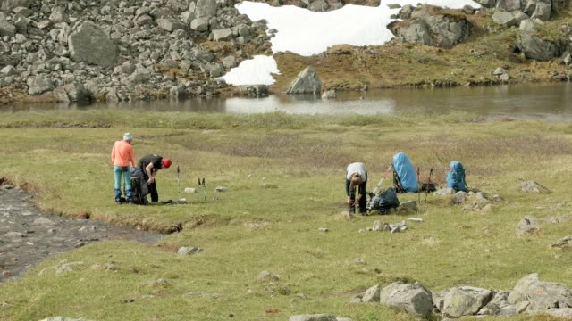Los-excursionistas-empacan-mochilas-en-el-campamento-de-montañas.-Noruega