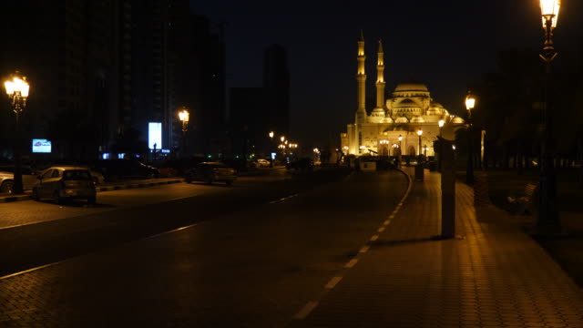 Nacht-zu-Fuß-zum-Al-Noor-Mosque-in-Sharjah.-Die-Allee-wird-durch-Laternen-beleuchtet.-Bau-der-Moschee-ist-mit-goldenen-Lichtern-beleuchtet.