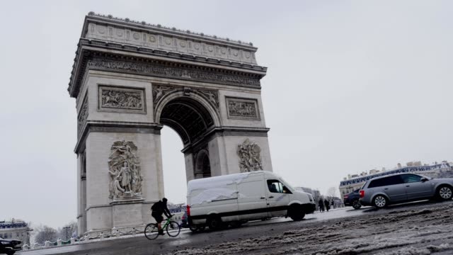El-arco-del-triunfo-por-un-raro-día-de-nieve-en-París,-Francia