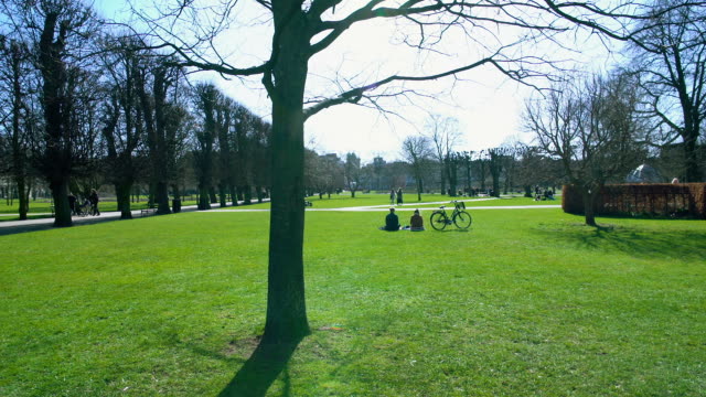 Parque-de-la-ciudad-de-Copenhague-en-día-soleado,-gente-de-vacaciones-relajante-en-hierba-verde