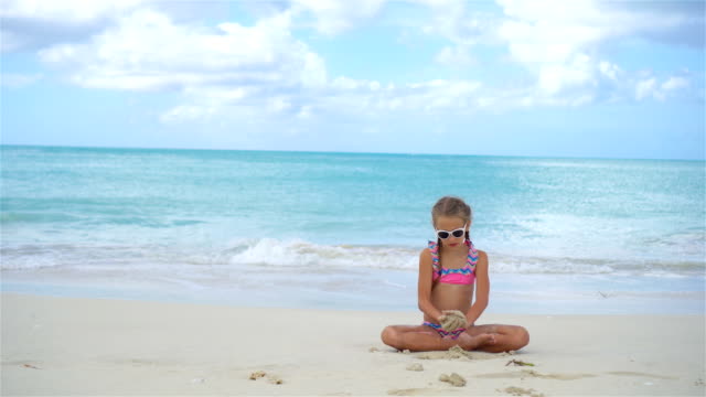 Entzückende-kleine-Mädchen-am-Strand-während-der-Sommerferien