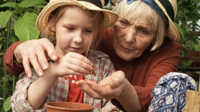 Grandmother-and-Granddaughter-Planting-Seed-Heads