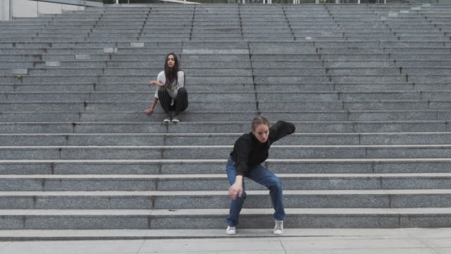 Girl-Sits-on-Steps-Another-Girl-Dances-on-Steps