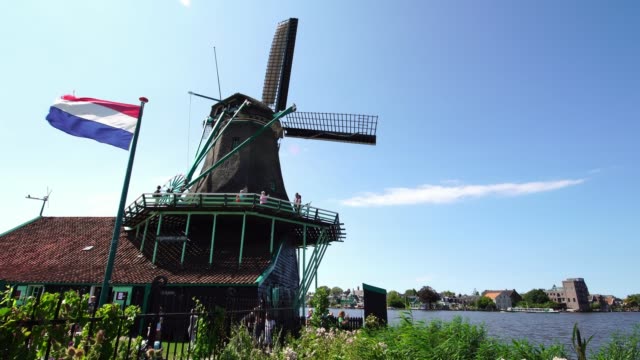 Tourists-couple-taking-pictures-of-traditional-Windmills-at-the-Zaanse-Schans-near-Amsterdam,-Holland
