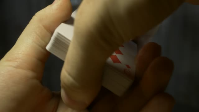 Hände-halten-Stapel-Spielkarten-auf-Holztisch