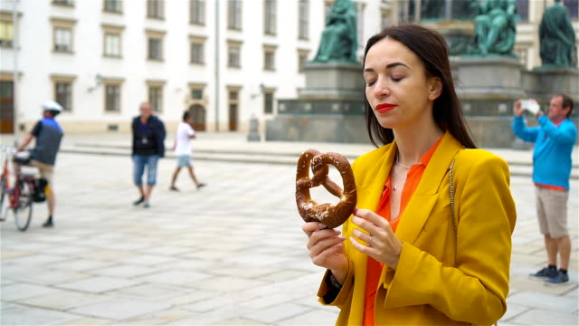 Hermosa-joven-sosteniendo-pretzel-y-relajante-en-el-Parque