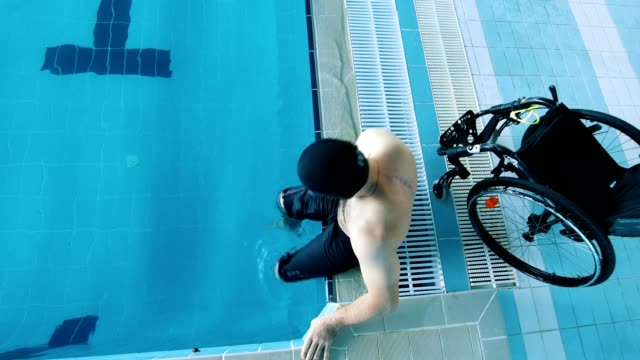Disabled-man-gets-in-the-swimming-pool.-High-view