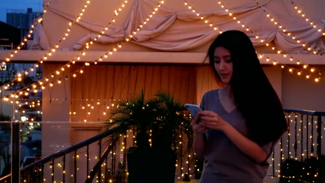 Asiatische-Frau-machen-Selfie-mit-ein-Telefon-bei-Nacht-City-auf-Dachterrasse-Hotel.