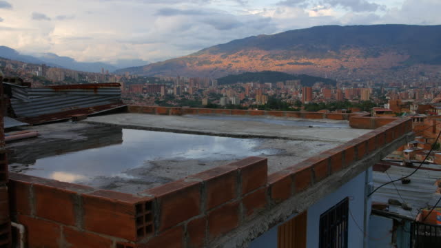Rooftop-in-"Comuna-13"-Medellin-Colombia-with-beautiful-water-reflection-at-evening