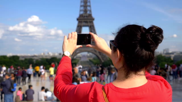 Frau-unter-Bild-des-Eiffelturms-mit-Smartphone-in-Zeitlupe-180fps