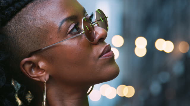 Fashionable-young-black-woman-in-sunglasses,-head-shot,-side-view,-bokeh-lights-in-background