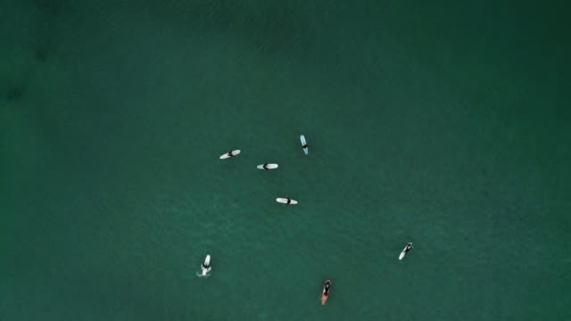Aerial-Shot-of-Surfers-in-the-Sea
