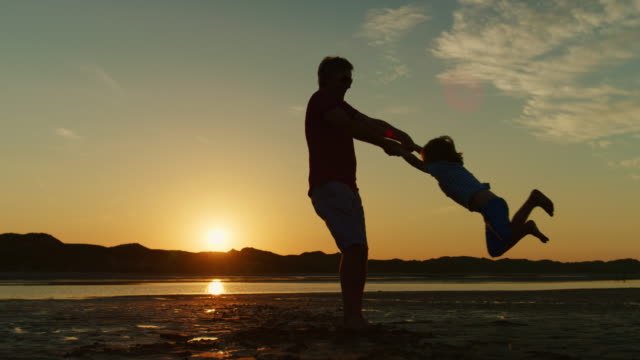Silhouette-Of-Father-And-Son-Playing-Together-At-The-Beach.