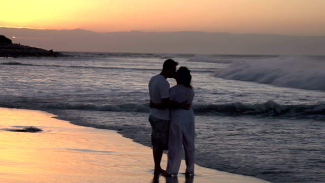 Paar-genießen-einen-romantischen-Umarmung-am-Strand-silhouette,-Südafrika