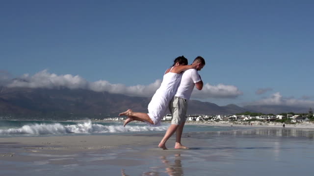 Cámara-lenta-de-giro-alrededor-de-Pareja-romántica-en-la-playa,-la-Ciudad-del-Cabo,-Sudáfrica