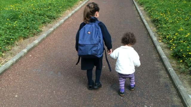 Joven-hermana-camina-con-su-hermana-mayores-a-escuela