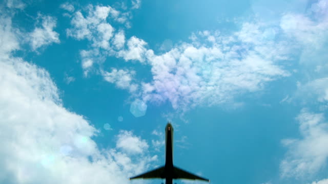 Airliner-Flying-Overhead-with-Sun-Flares-and-Blue-Sky