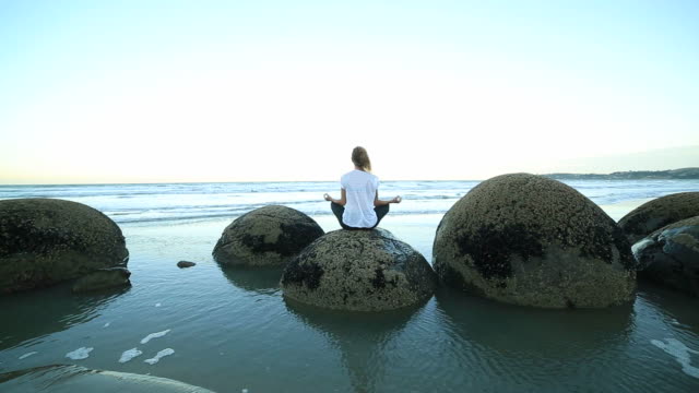 Mujer-agarrando-la-posición-del-loto-yoga-en-boulder