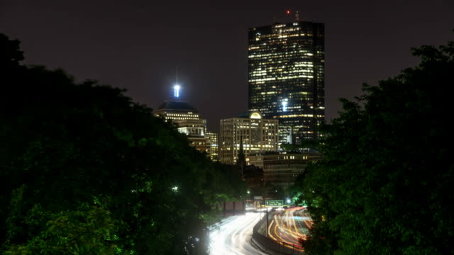 Boston-Verkehr-in-der-Nacht-Zeitraffer.--Belebten-Stadt-Bewegung-entlang-dem-Storrow-Drive,-Blick-auf-die-Hochhäuser-Downtown.