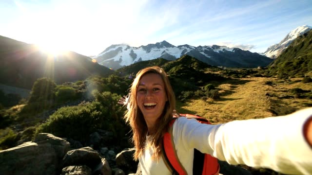 Junge-Frau-dauert-Selbstporträt-auf-Berge-im-Hintergrund