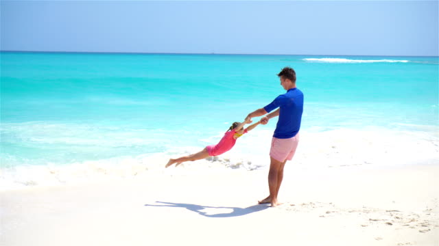 Little-girl-and-happy-dad-having-fun-during-beach-vacation