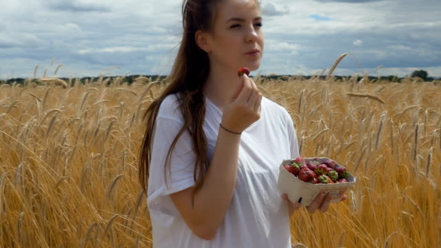 Bogen-um-ein-Mädchen-mit-Erdbeeren-in-einem-Weizenfeld