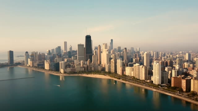 Vista-aérea-de-Chicago,-Estados-Unidos-temprano-en-la-mañana.-Drone-volando-sobre-el-lago-Michigan-en-el-amanecer