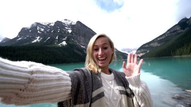 Young-woman-taking-selfie-portrait-at-Lake-Louise