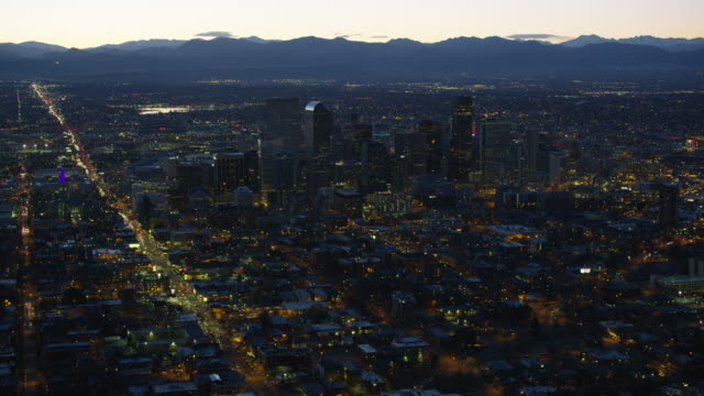 Aerial-view-of-Denver-at-night-with-Rocky-Mountains-in-background