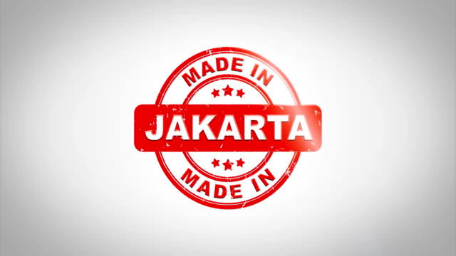Made-In-JAKARTA-unterzeichnet,-Stanz-hölzernen-Stempel-Textanimation.-Roter-Tinte-auf-Clean-White-Paper-Oberfläche-Hintergrund-mit-grünen-matten-Hintergrund-enthalten.