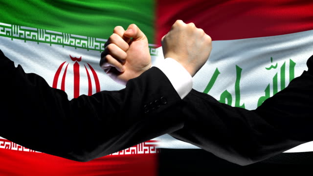 Iran-gegen-Irak-Auseinandersetzung,-Ländern-Meinungsverschiedenheiten,-Fäusten-auf-Flagge-Hintergrund