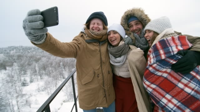 Joyful-Young-Tourists-Photographing-Outdoor-at-Winter-Day