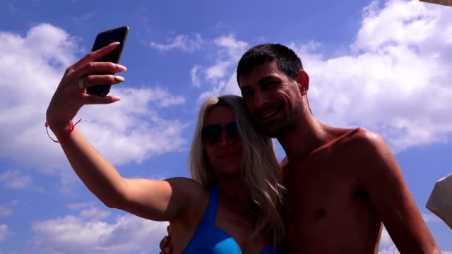 Young-couple---girl-and-young-man-doing-selfie-on-mobile-phone